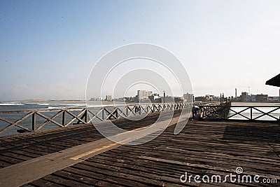 old wooden pier with railing in the pacific ocean and blue sky pimentel chiclayo per Stock Photo