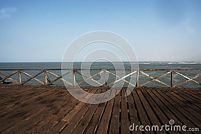 old wooden pier with railing in the pacific ocean and blue sky pimentel chiclayo per Stock Photo