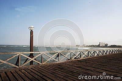 old wooden pier with railing in the pacific ocean and blue sky pimentel chiclayo per Stock Photo