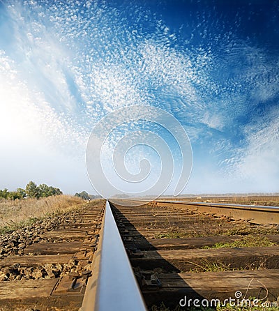 Old wooden rail closeup and blue sky with clouds Stock Photo