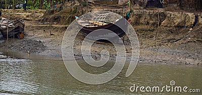 Old wooden rustic boat ported on a bank of a small river with fresh water Stock Photo