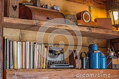 Old wooden shelf with journals and antique objects Stock Photo
