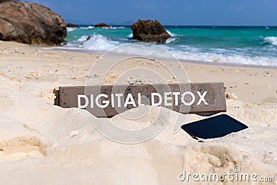 Old wooden sign with text digital detox on tropical beach Stock Photo