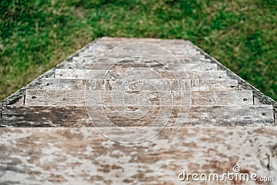 Old wooden stairs going down on a background of green grass. Top view. Copy, empty space for text Stock Photo