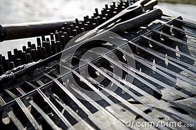 Old wooden stringed musical instrument stands under the open sky Stock Photo