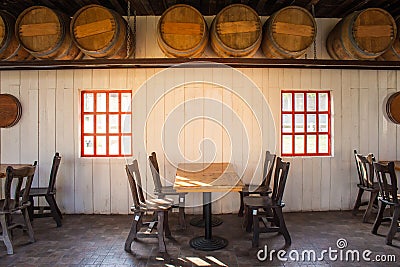 Old wooden table and chairs locate in restaurant with wooden wine barrel interior in restaurant. Stock Photo