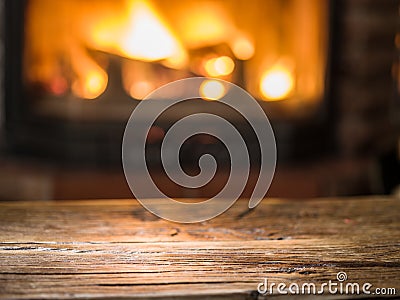 Old wooden table and fireplace with warm fire. Stock Photo