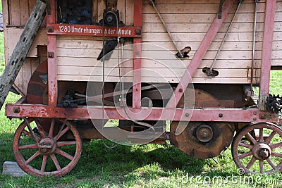 Old wooden threshing machine with flywheel and belt drive Stock Photo