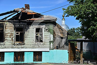 The old wooden village house after fire and church Stock Photo