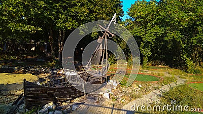 An old wooden weathered wrecked boat with a leaning mast. Stock Photo