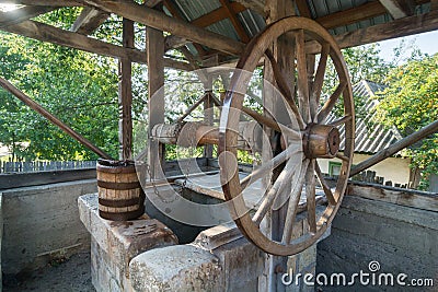 Old wooden well with large wheel Stock Photo