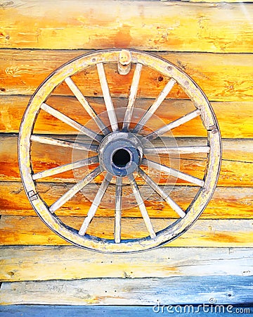 Old Wooden Wheel On wooden wall Stock Photo