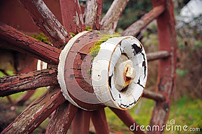Paint on a red wooden wheel weathers. Stock Photo