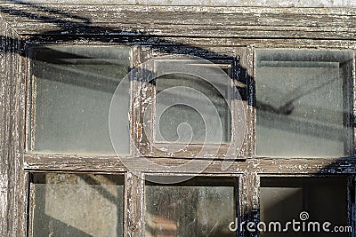An old wooden window with dusty panes. The facade of an abandone Stock Photo