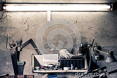 Old work tools, shelf on a wall over an old vintage workbench in a home garage Stock Photo