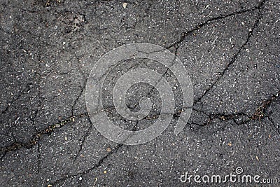 Old worn and cracked asphalt with cracks. Urban texture. A smooth dark grey asphalt pavement texture. Stock Photo