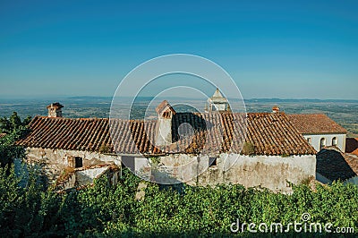 Old worn house and green bushes with landscape with trees Stock Photo