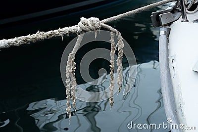 Old worn mooring rope of a yacht marine background. Stock Photo