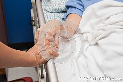 Old wrinkled hand touches and holds young hand Stock Photo