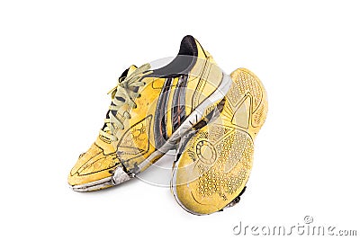 Old yellow futsal sports shoes and the insole is damaged on white background football sportware object isolated Stock Photo