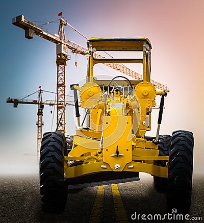 Old yellow motor grader on the road Stock Photo