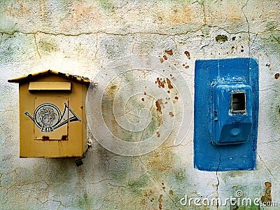 Old yellow postal box and blue electricity meter on a colourful wall, Monemvasia, Greece Editorial Stock Photo