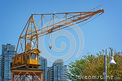 Old yellow vintage industrial loading crane on Granville Island, Vancouver, British Columbia Canada Stock Photo