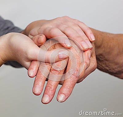 Old and young hand with walking stick Stock Photo
