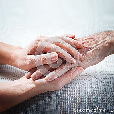 Old and young holding hands on light background, closeup. Care is at home of elderly Stock Photo