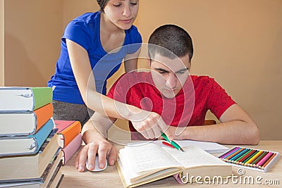 Older brother and Student sister reading Books At Desk In Living Room Stock Photo