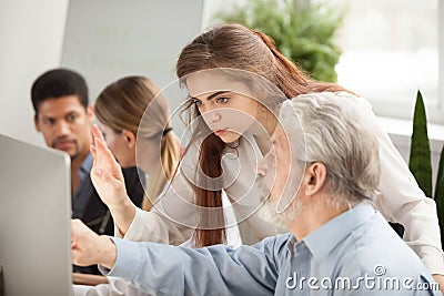 Older employee asking young manager question about online comput Stock Photo