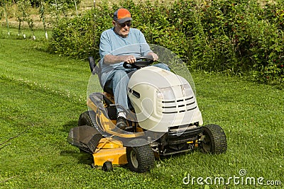 Older Gentleman Cutting Grass On Riding Lawnmower Stock Photo