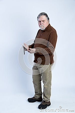 Older gentleman holding picture frame and scowling Stock Photo