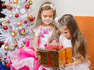 Older girl gives younger unwanted gift Stock Photo
