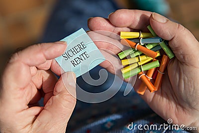 Older hands holding lottery tickets, Ticket with german text Stock Photo