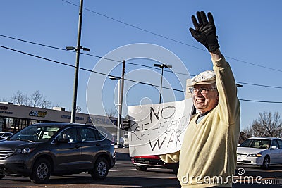 Older man at Iran anti-war protest waving and holding sign saying no re-election war Editorial Stock Photo