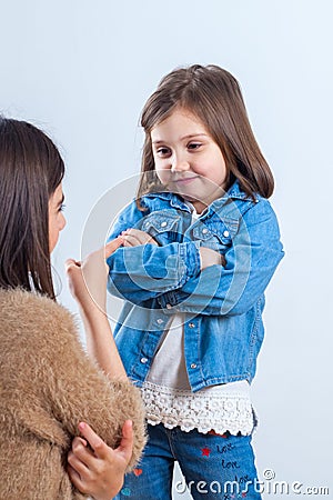Older sister gives a remark to the younger one with a finger Stock Photo