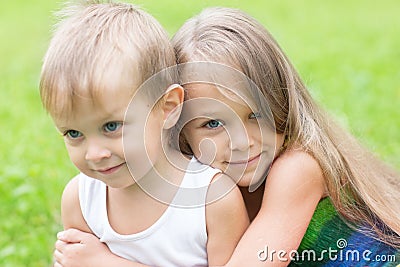 Older sister hugging little brother Stock Photo