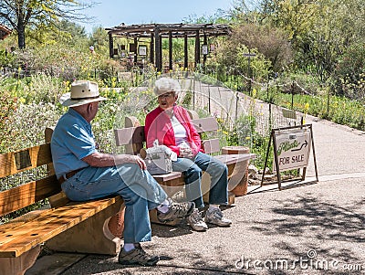 Older visitors relax on benches on spring day at Tohono Chul Park, Tucson Editorial Stock Photo