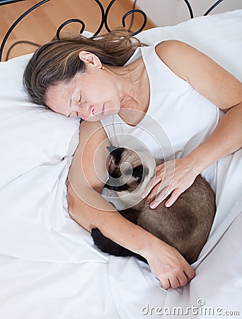 Older woman with cat sleeping Stock Photo