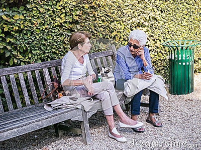 Older woman companions chat on a bench in a Paris park Editorial Stock Photo