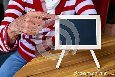 Older womans hand pointing at a blackboard Stock Photo