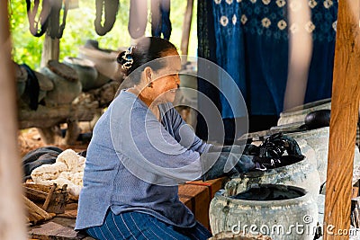 Older women dyeing cotton with natural indigo. Local Master are the original Indigo Cotton Weaving in the community of Sakon Stock Photo