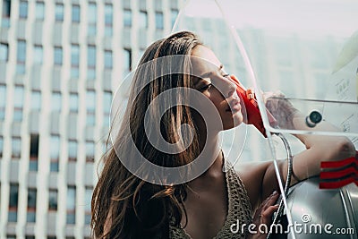 Oldfashion town. Woman with payphone. Vintage concept. Communication. Oldstyled city. Stock Photo