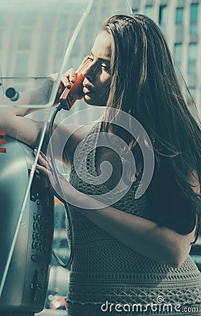 Oldstyled city. Vintage concept. Woman with payphone. Communication. Old fashion town. Stock Photo