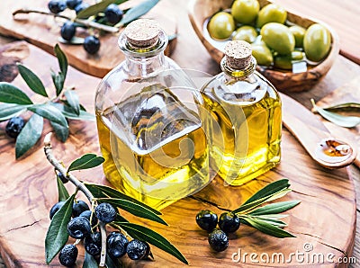 Olive oil and berries are on the olive wooden tray. Stock Photo