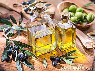 Olive oil and berries are on the olive wooden tray. Stock Photo