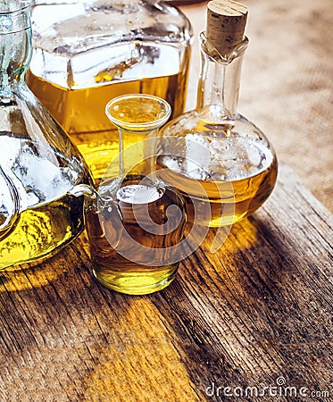 Olive oil bottles variety on a wooden table, closeup view Stock Photo