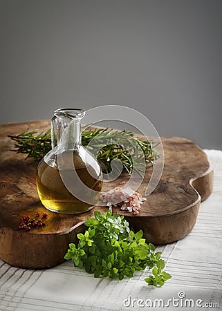 Olive oil with fresh spices on a wood board Stock Photo