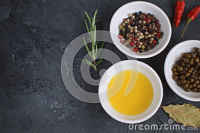 Olive oil porcelain plate Rosemary Bay leaf branch Pepper mix Cooking concept Seasoning Spices Black concrete background Stock Photo
